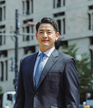 青いスーツを着た代表取締役COO塚田壮一朗氏の写真