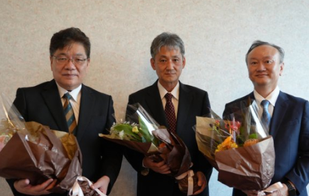 花束を持つ3人の男性の集合写真