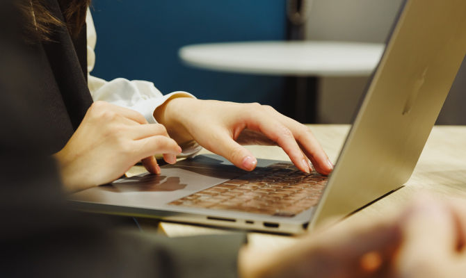 ノートパソコンを操作するビジネスウーマンの手元